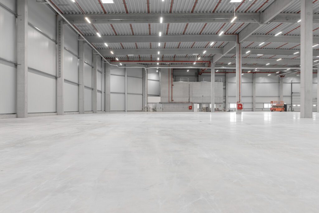 Leere Industriehalle mit glänzendem Boden und hohen Decken